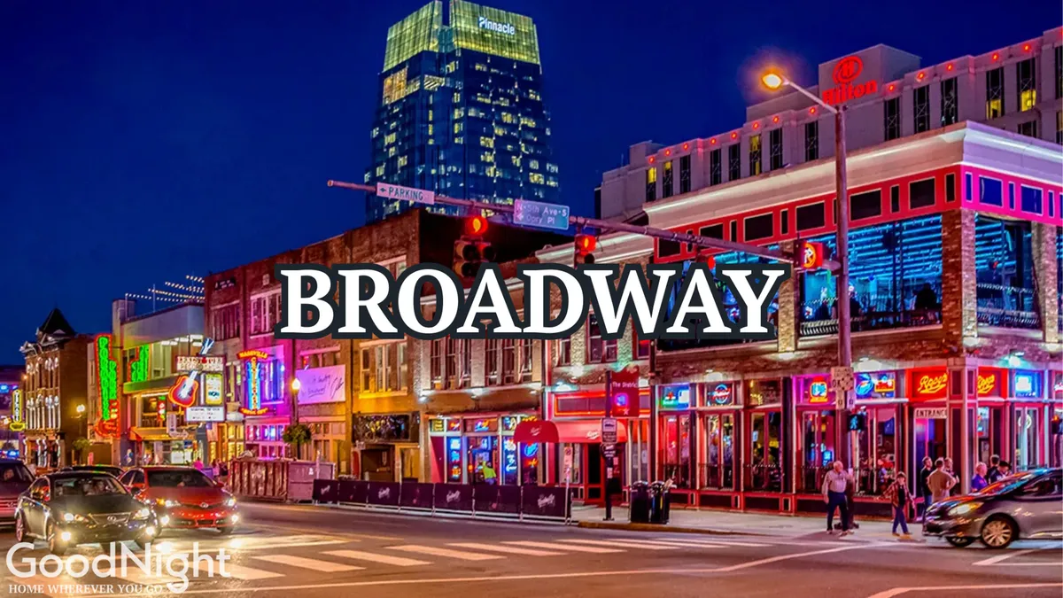 This vibrant exterior shot captures neon signs, colorful storefronts, and crowds of people enjoying Nashville’s energetic nightlife. The scene is filled with the hustle and bustle of Broadway, with illuminated streets and music venues clearly visible, encapsulating the excitement of Music City after dark.