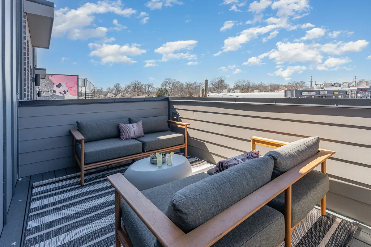 This exterior image features a cozy outdoor seating arrangement with a coffee table and decorative pillows, creating a comfortable and inviting space for guests to relax, converse, or enjoy the view.