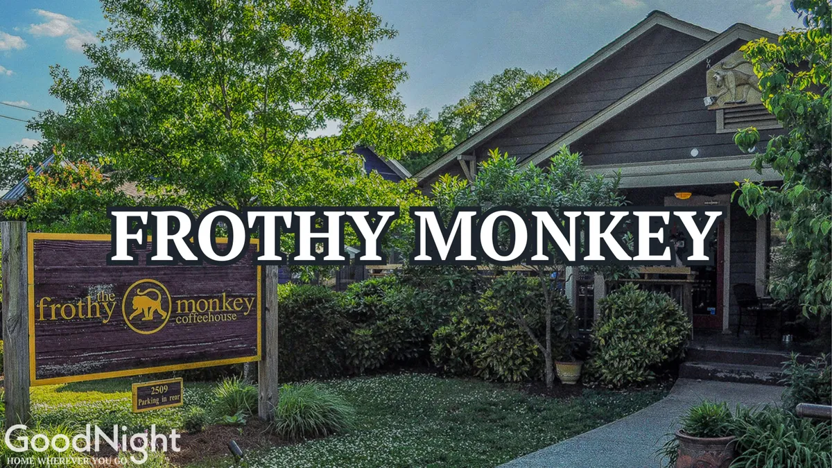 The exterior of Frothy Monkey, with charming landscaping and clear signage, inviting patrons to enjoy coffee on the patio. The setting is casual and community-focused, highlighting a popular local café.